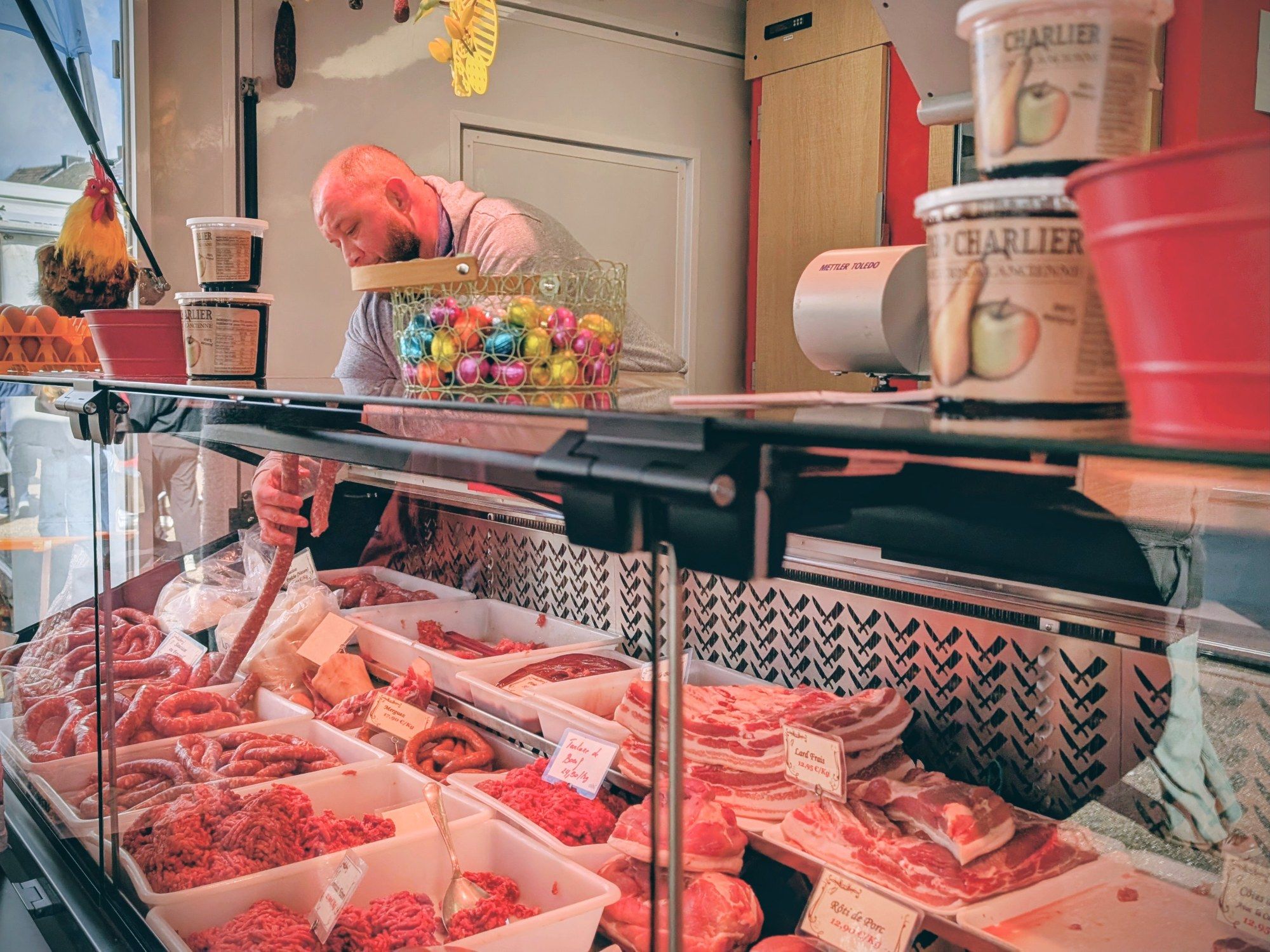 Gauthier Collin derrière la vitrine de saucisses et de viande de porc
