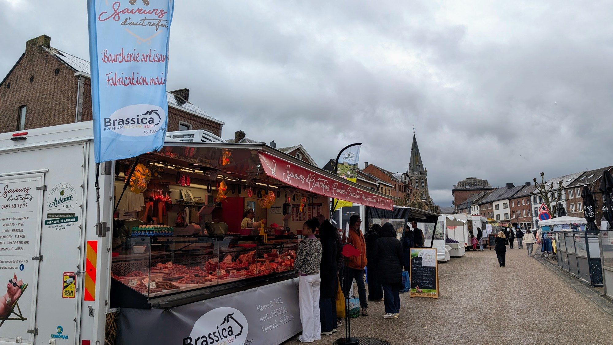 Le stand Saveurs d'Autrefois sur le marché dominical d'Aubel, avec l'église en arrière-plan